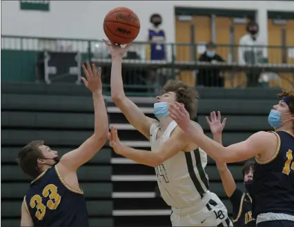  ?? PHOTOS BY KEN SWART — FOR MEDIANEWS GROUP ?? Brennan Jones of Lake Orion puts up a shot between Oxford’s Tristan Bennett (33) and Mitchell Viviano (14) during the OAA Blue matchup played on Thursday at Lake Orion High School. The Dragons defeated the Wildcats 43-30.