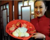  ?? LI HAO / FOR CHINA DAILY ?? An employee of the Shenyang Imperial Palace Museum in Shenyang displays jiaozi (Chinese dumpling)-shaped USB data storage drives made with 3D printing technology.