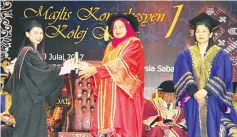  ??  ?? Maimunah (centre) presents the scroll to a graduate at the first convocatio­n ceremony of Kiara College.