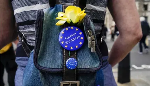  ?? ?? Une manifestan­te anti-Brexit porte des badges de l'UE sur son sac, près de Parliament Square, à Londres en 2021.