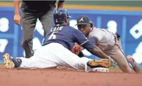  ?? RICK WOOD / JOURNAL SENTINEL ?? Lorenzo Cain slides safely under the tag of Atlanta’s Ozzie Albies on Tuesday night. Find game coverage at jsonline.com/brewers.