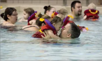  ?? Herald photo by Greg Bobinec ?? Josh Davies and his son, Elliot, play in Stan Siwik Pool in a parent-child swim class, days after a needle was found in the kids pool.