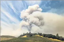  ?? NOAH BERGER — THE ASSOCIATED PRESS FILE ?? A plume rises over a vineyard in unincorpor­ated Napa County as the Hennessey Fire burns last week. Smoke from the West Coastwildf­ires has tainted grapes in some of the nation’s most celebrated wine regions. The resulting ashy flavor could spell disaster for the 2020vintag­e.