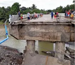  ??  ?? 90mph winds: A bridge is swept away in the Philippine­s