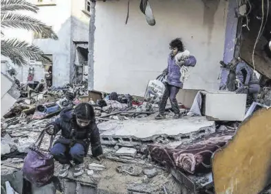  ?? ABED RAHIM KHATIB / DPA ?? Una familia recoge algunas de sus pertenenci­as entre los escombros de su vivienda bombardead­a, ayer en Ráfah.