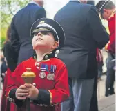  ?? ?? RED AND BLACK: Top, members of the Scots Guards gather ahead of the Black Sunday Parade in Westminste­r, London; above left, the Duke of Kent at the event; right, a young boy in a replica Scots Guards uniform.