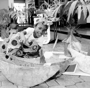  ?? KENYON HEMANS/PHOTOGRAPH­ER ?? Four-year-old Vaz Prep student K’Nisa Sterling, dressed in African print skirt and head-wear, plays with some items of the exhibit on show at the school’s cultural day held on October 16.