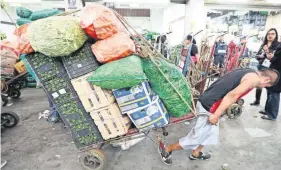  ??  ?? La mayoría de los carretille­ros que circulan de un lado a otro con mercancía pesada son jóvenes quienes tuvieron que buscar un empleo para solventar los gastos de una nueva familia.