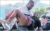  ?? Picture: S’BONELO NGCOBO ?? Phiwe Ngubane carries Mmeli Khawula, who was wounded in a protest on North Coast Road on June 6.