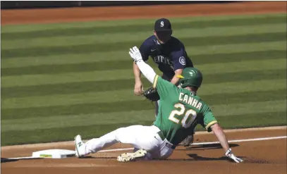  ?? JED JACOBSOHN — THE ASSOCIATED PRESS ?? The A’s Mark Canha slides safely into third as the Mariners’ Kyle Seager applies the tag during the first inning of their first game of a doublehead­er in Oakland on Saturday.