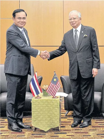  ??  ?? DOUBLING DOWN: Prime Minister Prayut Chan-o-cha and Malaysian counterpar­t Najib Razak are both controvers­ial heads of government overseeing countries with bitter political divisions.