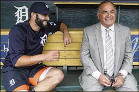  ?? CARLOS OSORIO / ASSOCIATED PRESS ?? The Tigers’ Alex Avila (left) shares a laugh recently with his dad, general manager Al Avila, in the dugout in Detroit. Al seeks a balance between business and personal with his son.