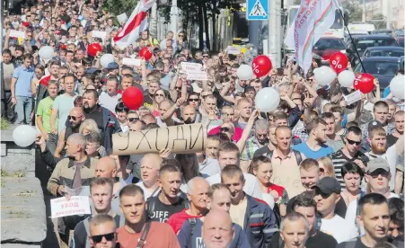  ?? DMITRI LOVETSKY, THE ASSOCIATED PRESS ?? Workers with handmade posters reading “Go away!” march toward the Minsk Wheel Tractor Plant where Belarusian President Alexander Lukashenko was addressing employees in Minsk, Belarus on Monday.