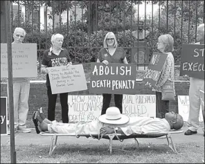  ?? SHERRY SIMON via AP ?? Pulaski County Circuit Judge Wendell Griffen lies on a gurney outside the Governor’s Mansion during a protest against the death penalty Friday. Griffen, who issued a restrainin­g order Friday in a lawsuit by the maker of one of the lethal drugs that...