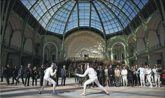  ?? YOAN VALAT / AP ?? French fencers display their moves at the Grand Palais in Paris on Monday. The iconic venue is set to host this year’s fencing and taekwondo Olympic events.