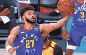  ?? KEVIN C. COX/GETTY IMAGES ?? The Nuggets’ Jamal Murray goes up for a shot against the Jazz during the first quarter on Sunday.