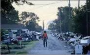  ?? DAVID GOLDMAN — THE ASSOCIATED PRESS FILE ?? A man walks past debris from homes on his street damaged in flooding from Hurricane Harvey in September 2017.