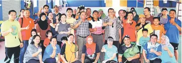  ??  ?? Hasbi (standing front, fifth right) joins the shuttlers and members of the organising committee in a group photo at the closing of the badminton tournament.