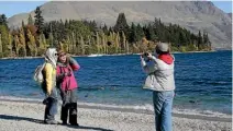  ??  ?? Tourists enjoy Queenstown’s lakefront.