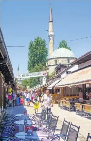  ??  ?? CITY LIFE: A typical Sarajevo scene, with the Havadze Duraka Mosque close to local life.