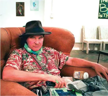  ?? ?? El actor Val Kilmer, en su estudio de California, con la electrolar­inge que usa ahora para comunicars­e