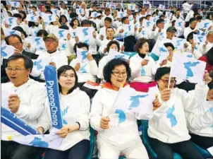  ?? JUNG YEON-JE/AFP ?? South Korean fans wave ‘unificatio­n flags’ as they cheer for North Korean players during the IIHF women’s world ice hockey championsh­ips division II group A match between South Korea and North Korea in Gangneung on April 6.