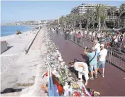  ?? VALERY HACHE/AGENCE FRANCE-PRESSE VIA GETTY IMAGES ?? People visit a makeshift memorial in Nice in tribute to the victims of the deadly Bastille Day attack that killed 84.