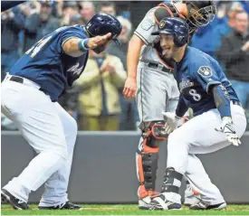  ?? BENNY SIEU / USA TODAY SPORTS ?? Jesus Aguilar (left) greets Ryan Braun at home after Braun’s three-run homer in the sixth inning Thursday night.