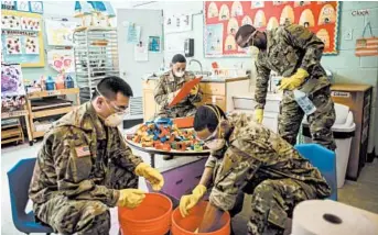  ?? ANDREW SENG/THE NEW YORK TIMES ?? Members of the National Guard disinfect toys last month at a Jewish community center in upstate New York.