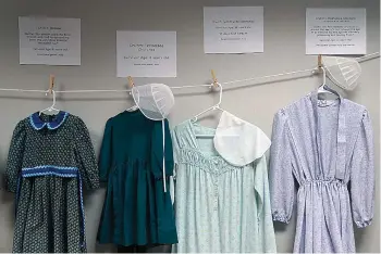  ?? AP Photo/Jessie Wardarski ?? Dresses donated by sexual assault survivors from Amish and other plain-dressing religious groups hang on a clotheslin­e beneath a descriptio­n of each survivors' age and church affiliatio­n on April 29 in Leola, Pa. The exhibit's purpose was to show that sexual assault is a reality among children and adults in such groups. Similar exhibits held nationwide aim to shatter the myth that abuse is caused by a victim's clothing choice.