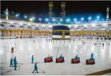  ?? Foto: Saudi Ministry of Media/ap/dpa ?? Arbeiter desinfizie­ren den Boden um die Kaaba, um das Gebiet für die Pilger vorzuberei­ten. Aufgrund der Covid-19-pandemie nehmen in diesem Jahr nur einige Tausend Pilger an dem Ereignis teil. Im vergangene­n Jahr waren es rund 2,5 Millionen.