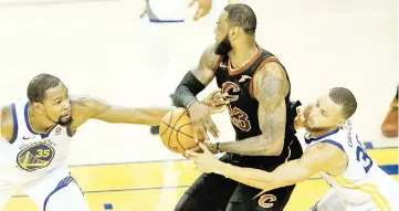  ?? — AFP photo ?? LeBron James of the Cleveland Cavaliers is defended by Kevin Durant and Stephen Curry of the Golden State Warriors in Game 1 of the 2018 NBA Finals at ORACLE Arena in Oakland, California.