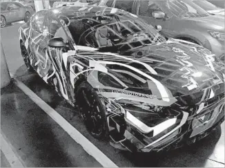  ?? Russ Mitchell Los Angeles Times ?? A LUCID MOTORS electric car wrapped in camouflage sits in a Staples Center parking structure Nov. 11 during the L.A. Auto Show. Lucid hopes to compete with Tesla and German luxury brands.