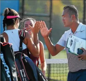  ?? PETE BANNAN — DIGITAL FIRST MEDIA ?? West Chester Henderson coach Peter Sok gives Emma Clark and Amanda Baxter high fives during Tuesday’s District 1 team final at Plymouth Whitemarsh.