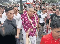  ?? REUTERS ?? Singapore Prime Minister and Secretary-General of the People’s Action Party Lee Hsien Loong (centre) and his team thank supporters after his general election victory.