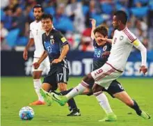  ?? AFP ?? UAE’s defender Abdul Aziz Hussain Haikal (right) passes the ball away as is he closed by Japan’s forward Genki Haraguchi during the World Cup 2018 qualifier last week.