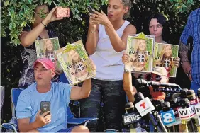  ?? CHRIS OMEARA/ASSOCIATED PRESS ?? Supporters of the late Gabby Petito hold up photos Wednesday in North Port, Fla., after potential human remains and items linked to her boyfriend, Brian Laundrie, were found.