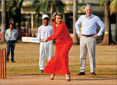  ?? REUTERS ?? Belgium’s King Philippe looks on as Queen Mathilde hits a ball as they play cricket with children at a ground in Mumbai on Friday, during their India visit.