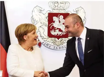  ?? FOTO: NIETFELD/DPA ?? Besuch mit Symbolwert – 25 Jahre nach dem „Augustkrie­g“zwischen Georgien und Russland: Bundeskanz­lerin Angela Merkel (CDU) und der georgische Ministerpr­äsident Mamuka Bachtadse reichen sich in Tiflis die Hände.