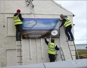  ??  ?? Members of Bettystown Tidy Towns erect one of the new banners.