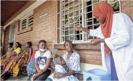  ?? /Reuters ?? Protection: A clinician demonstrat­es to clients how to take the cholera vaccine in response to the latest outbreak of the disease in Blantyre, Malawi.