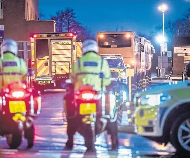  ??  ?? Quarantine­d cruise passengers on buses and under escort arrive at Arrowe Park Hospital last night