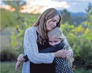  ??  ?? Kristen Kilmer, diagnosed with incurable breast cancer three years ago, hugs her daughter at their home in Spearfish, S.D.