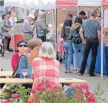  ?? RP-FOTO: JÖRG KNAPPE ?? An Bierzeltga­rnituren konnten die Besucher neben der Genussmeil­e des Marktes sitzen und französisc­he Spezialitä­ten wie Flammkuche­n zum Glas Wein genießen.