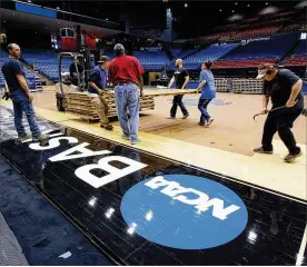  ?? STAFF / FILE ?? In happier times, stagehands remove the NCAA basketball floor from UD Arena in Dayton in preparatio­n for OHSAA Division II basketball games. In a typical year, UD Arena will host thousands of basketball-hungry fans in March. This year, with cancellati­on of many sporting events, is obviously not a typical year.