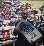  ?? CHARLES KRUP — THE ASSOCIATED PRESS ?? Democratic presidenti­al candidate and former Massachuse­tts Gov. Deval Patrick adds his campaign sign to pins, signs and bumper stickers of New Hampshire primary presidenti­al contenders on display in the State House visitors center Thursday.