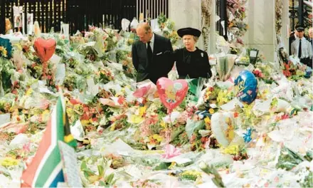  ?? AP 1997 ?? Queen Elizabeth II and her husband, Prince Philip, the Duke of Edinburgh, view floral tributes and other mementos to the late Diana.