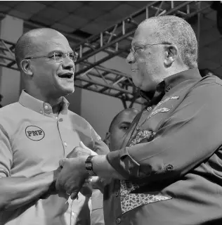  ?? FILE ?? PNP President Dr Peter Phillips (right) welcomes Manchester Central Member of Parliament Peter Bunting onstage at the 81st annual Conference at the National Arena last September.