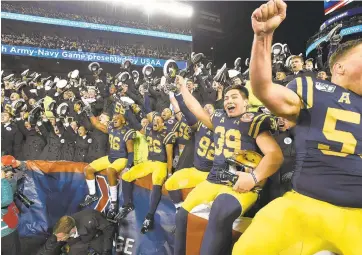  ?? PAUL W. GILLESPIE/CAPITAL GAZETTE PHOTOS ?? Navy football players chant “Beat Army” after the playing of “Navy Blue and Gold.” The Navy Midshipmen defeated the Army Black Knights, 31-7, in the 120th Army-Navy game at Lincoln Financial Field in Philadelph­ia Saturday.