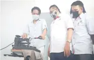  ??  ?? TAMBAH KEUPAYAAN: Anak lelaki Louna menunjukka­n kepada Mohd Salim mesin cetak heat press yang diberikan oleh RISDA untuk membantu menambah kapasiti keupayaan mereka mencetak baju.